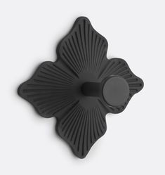 a black flower shaped object on a white surface