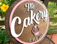 there is a sign that says the cakery and it has a cupcake on it