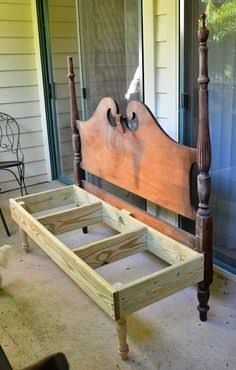 a wooden bed frame sitting on top of a floor next to a window in a room