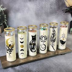 five jars with different designs on them sitting on a table