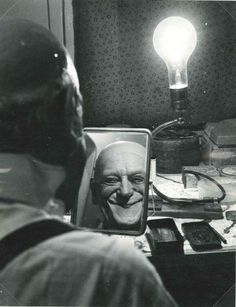 a man looking at himself in the mirror with a lightbulb on his head