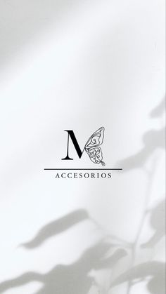 the letter m is placed on top of a white background with shadows from leaves and flowers