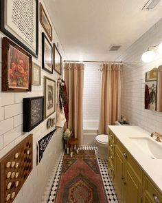 a bathroom with pictures on the wall and rug