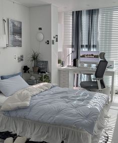 a bedroom with a bed, desk and chair next to a window covered in blinds