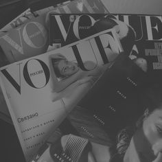 black and white photograph of magazines stacked on top of each other with woman's face