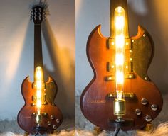 a guitar shaped lamp is lit up in the shape of an electric guitar with its head turned