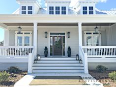 a large white house with porch and stairs