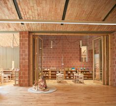 the interior of a children's playroom with wooden flooring and brick walls