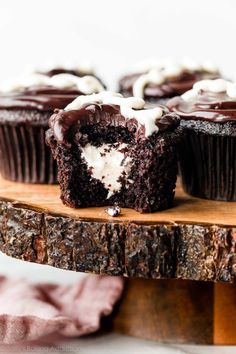 chocolate cupcakes with white frosting on a wooden tray