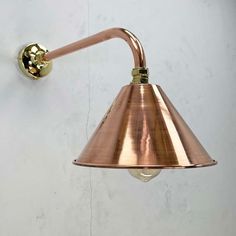 a copper colored wall light on a white wall