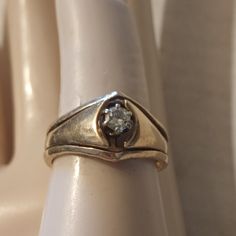 a close up of a ring on a white object with a diamond in the middle