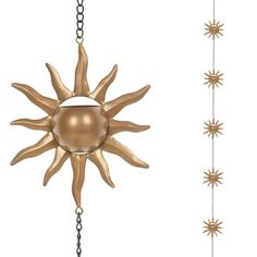 a sun - like object hanging from chains on a white background