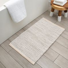 a bathroom with white towels and wooden stools