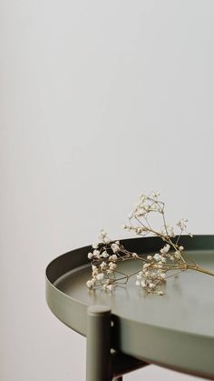 small white flowers are sitting on top of a metal tray that sits on a table