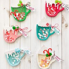 six handmade christmas ornaments hanging on a white wooden wall