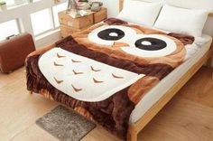 a bed with an owl blanket on top of it