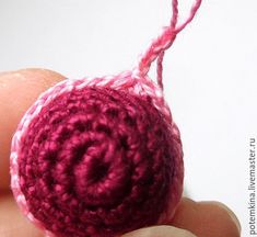 a hand holding a small crocheted object in it's palm