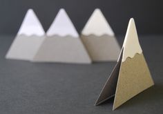 three folded paper mountains sitting next to each other