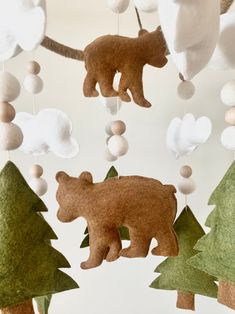 an ornament made to look like a bear in the woods with trees and balls hanging from it