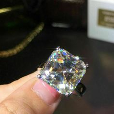 someone is holding a fancy diamond in their hand