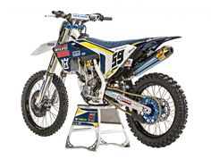 a blue and white dirt bike sitting on top of a stand