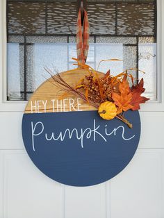 a sign that says hey there is pumpkin in front of a door with autumn leaves on it