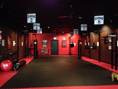 an empty gym with red walls and black flooring