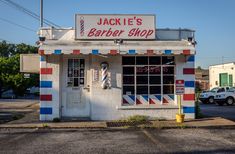 the jackie's barber shop is painted red, white and blue with stripes