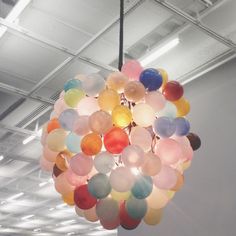 a chandelier made out of balloons hangs from the ceiling in an office building