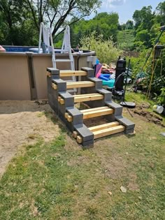 some steps made out of cinder blocks in the grass near an above ground swimming pool