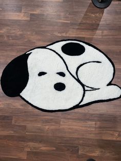 a black and white dog laying on top of a wooden floor