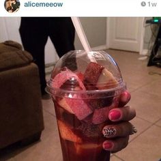 a person holding a cup with some food in it and a straw sticking out of it