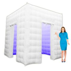 a woman standing next to an inflatable tent