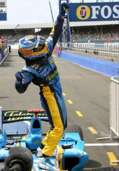 a man standing on top of a blue race car