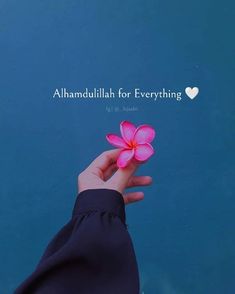 a person holding a pink flower in their left hand with the words, alhandullah for everything