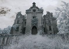 an old abandoned building in the middle of winter with snow on the ground and trees around it