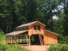 a large wooden building sitting on top of a lush green forest