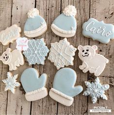 decorated cookies with frosting and decorations on a wooden surface, including mittens, gloves, snowflakes, hats, and hearts