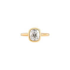 a gold ring with a square cut diamond in the center and a thin band around it