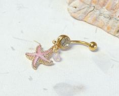 Starfish Belly Ring Show off your beautiful belly! Belly ring features a textured golden starfish charm with sparkly pink enamel accented with a hand wire wrapped pink agate bead. Belly button ring measures 1 3/4 inches long total length. Barbell is 14g gold plated surgical steel with a 10mm wearable bar length. For Belly Button Rings: https://www.etsy.com/shop/AllAboutClass?section_id=18474235&ref=shopsection_leftnav_1 For Industrial Barbells: https://www.etsy.com/shop/AllAboutClass?ref=l2- Starfish Belly Button Ring, Turtle Belly Button Rings, Cute Belly Ring, Beachy Belly Button Piercing, Cute Belly Rings Aesthetic, Summer Belly Rings, Gold Belly Button Piercing, Gold Belly Rings, Cute Belly Rings