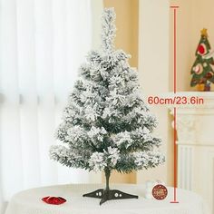 a small white christmas tree sitting on top of a table