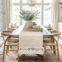 a dining room table with chairs and a rug on the floor in front of it