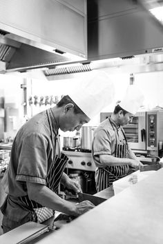 two chefs are in the kitchen preparing food