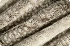 an animal fur rug is shown in grey and white colors, as well as the fur on