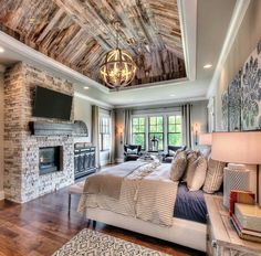 a large bedroom with a fireplace and tv