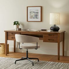 a desk with a chair, lamp and pictures on the wall