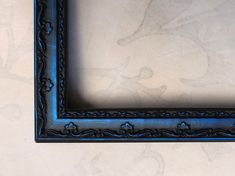 an ornate blue frame on a white wall