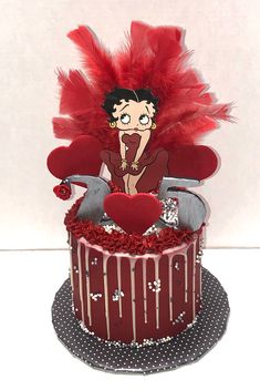 a cake decorated with red feathers and decorations