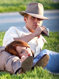 a man and woman laying in the grass