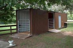 there is a small shed in the middle of a field with trees and grass around it